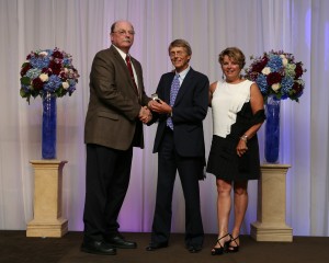Thoroughbred trainer Phil England accompanied by his wife Debra is presented with his Hall of Fame ring by Dr. Tim Yatcak of the CHRHF Planning Committee